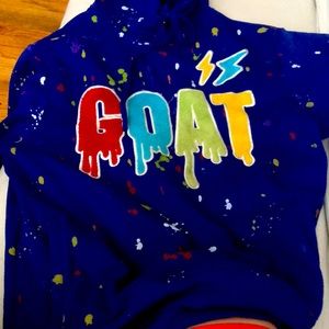 Mens, purple sweater with “goat” in drippy letters
